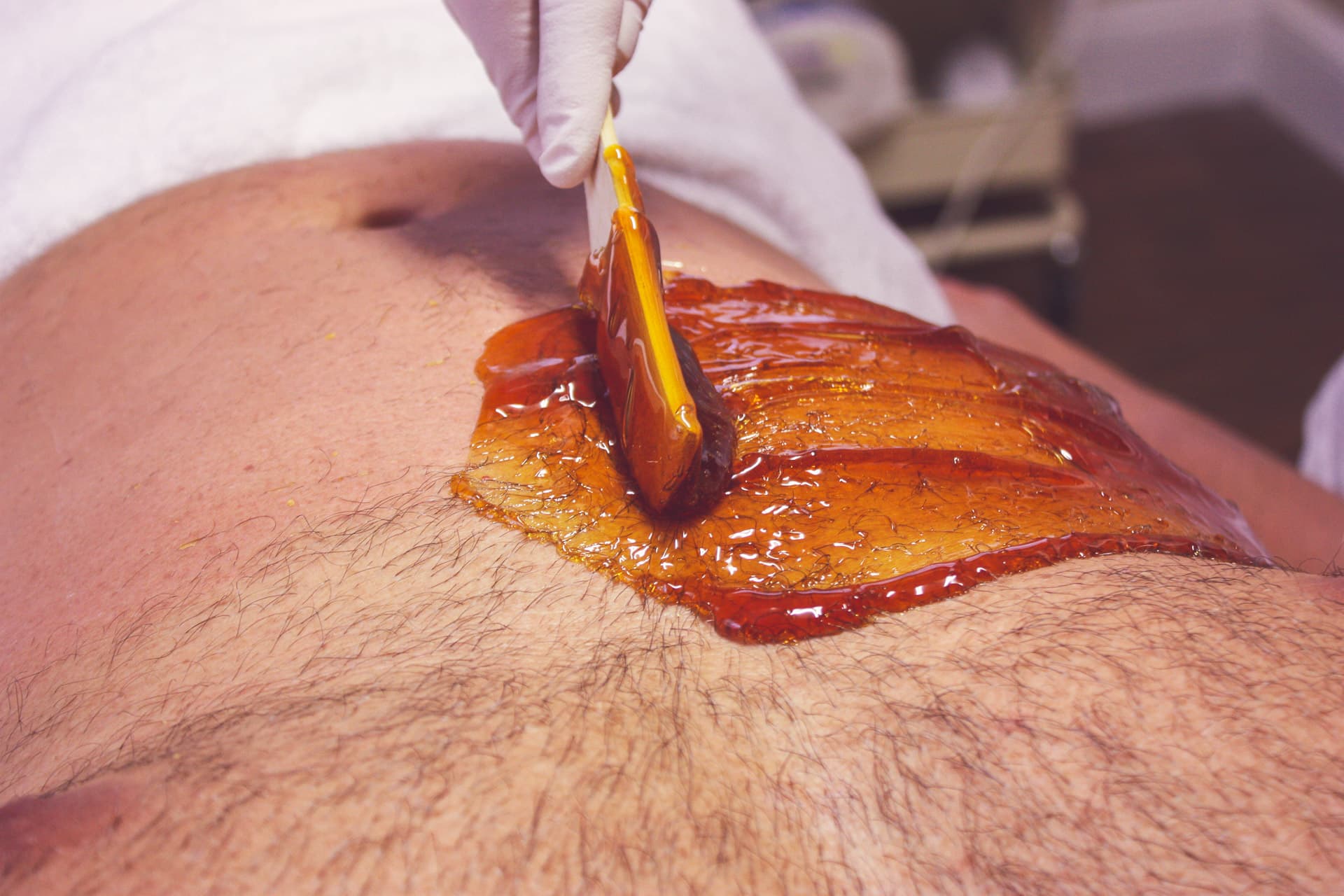 man getting a 'bro-zilian' brazilian waxing of the chest and stomach