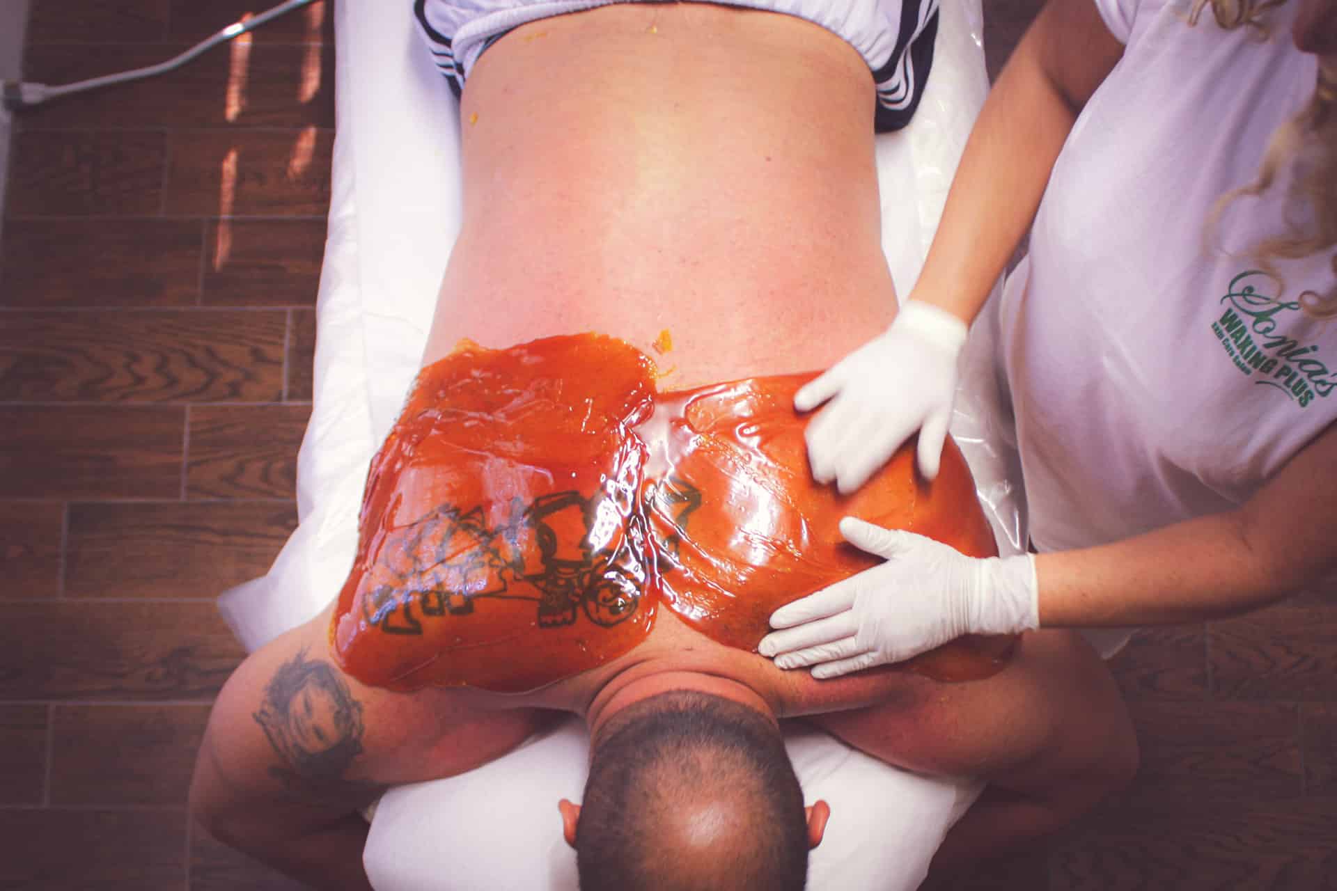 a man receiving a back waxing