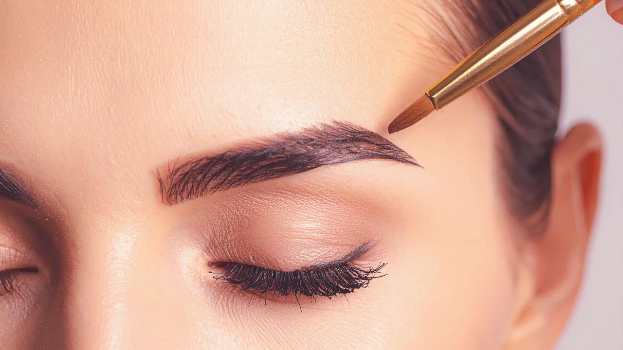 a person tinting their eyebrows